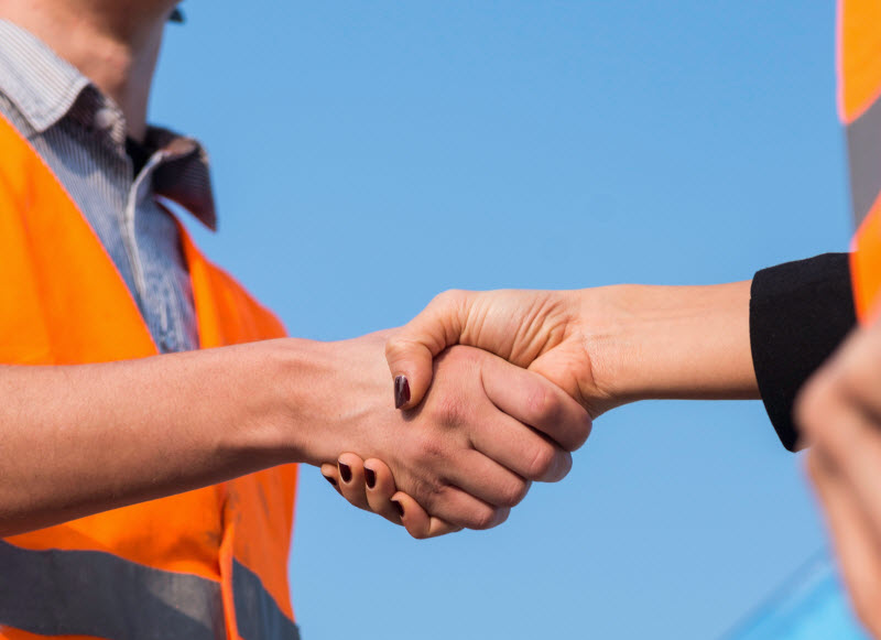 Civil engineers handshaking on construction site after successful meeting