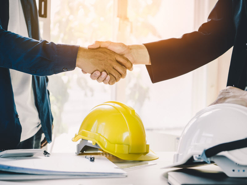 male architect shaking hands with client in construction site